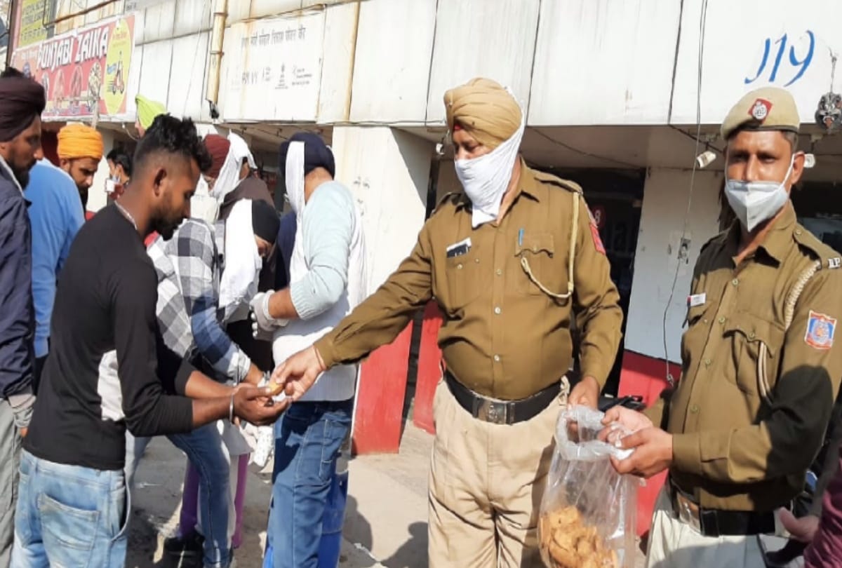 Delhi police help protesting farmers distribute food products among them at singhu border