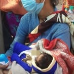 बेटे को गोद में लेकर बैठी पीड़ित महिला