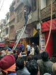 सुर्ती हट्टा रोड स्थित मकान में लगी आग को बुझाने का प्रयास करते फायर सर्विस के लोग।