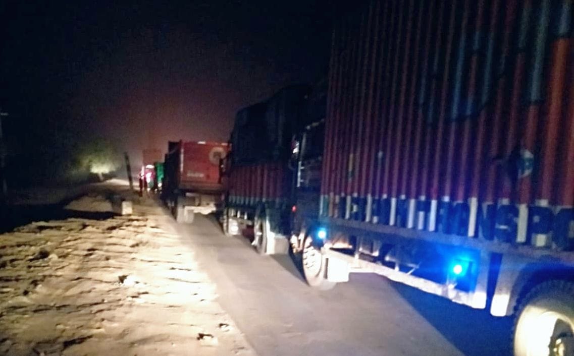 Truck stuck under construction bridge, jam