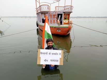 हाथ में तिरंगा लेकर गंगा में खड़ा शख्स।