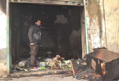 शहर के पक्कापुल के पास आग से जला सामान दिखाता गौरव।