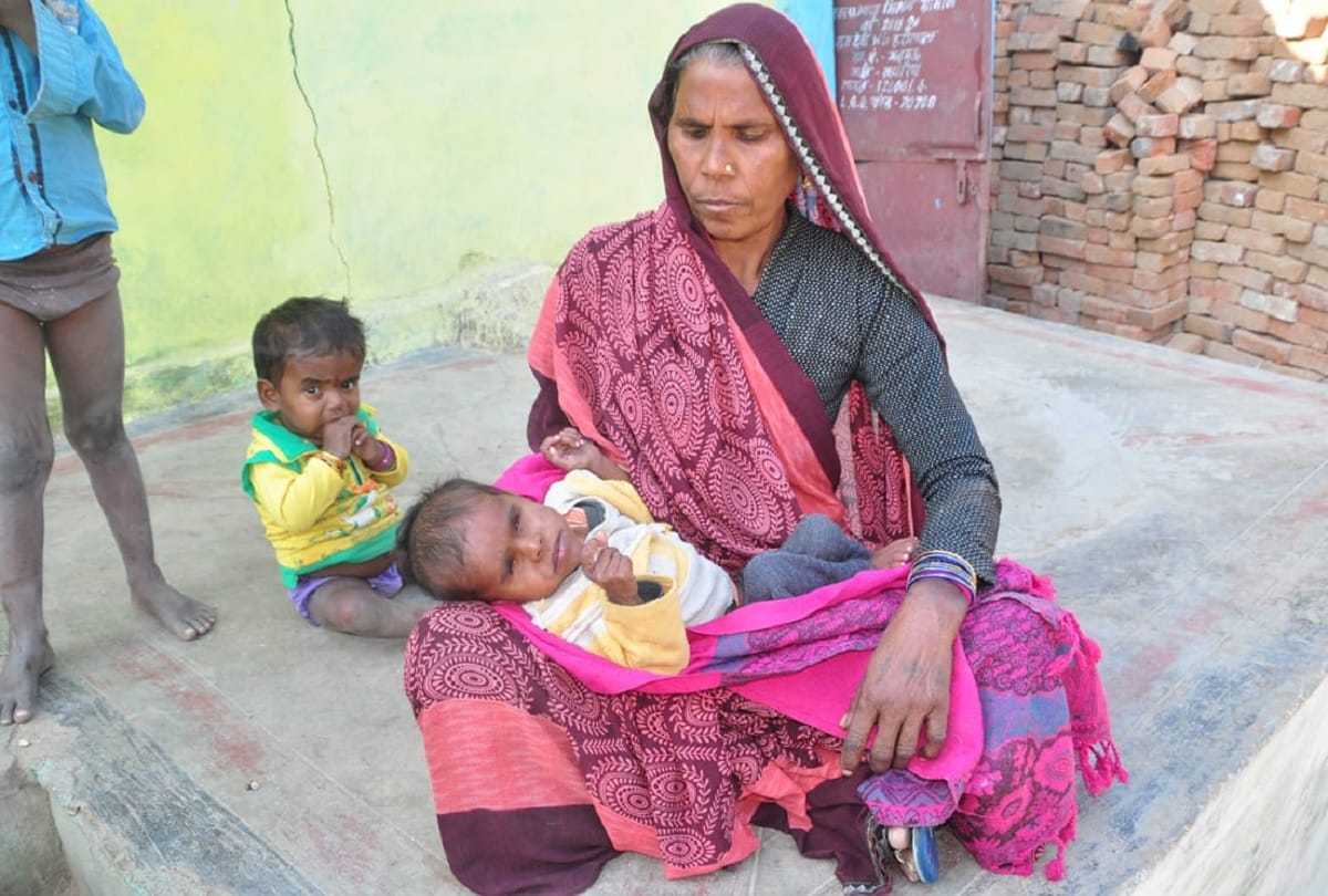 गढ़मऊ गांव में कुपोषण के कारण चलने-फिरने में असमर्थ पांच साल के इंदर को गोद में लेकर बैठी दादी सुखदेवी