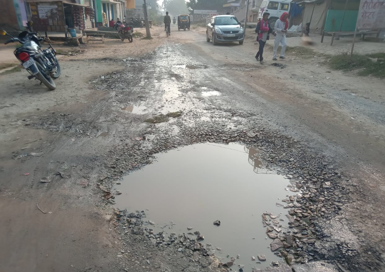 Pothole on the way, people walking
