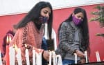 सैन्ट्रल मैथोडिस्ट चर्च में मोमबत्ती जलाकर प्रार्थना करती युवती।