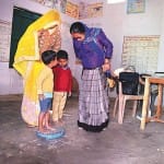 गांव उद्दैतपुर अभई के आंगनबाड़ी केंद्र पर बच्चों का वजन करती कार्यकत्री।