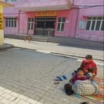 बुलंदशहर पोषण पुनर्वास केंद्र के बाहर जमीन पर बैठा अपने कुपोषित बच्चे के साथ हेमंत