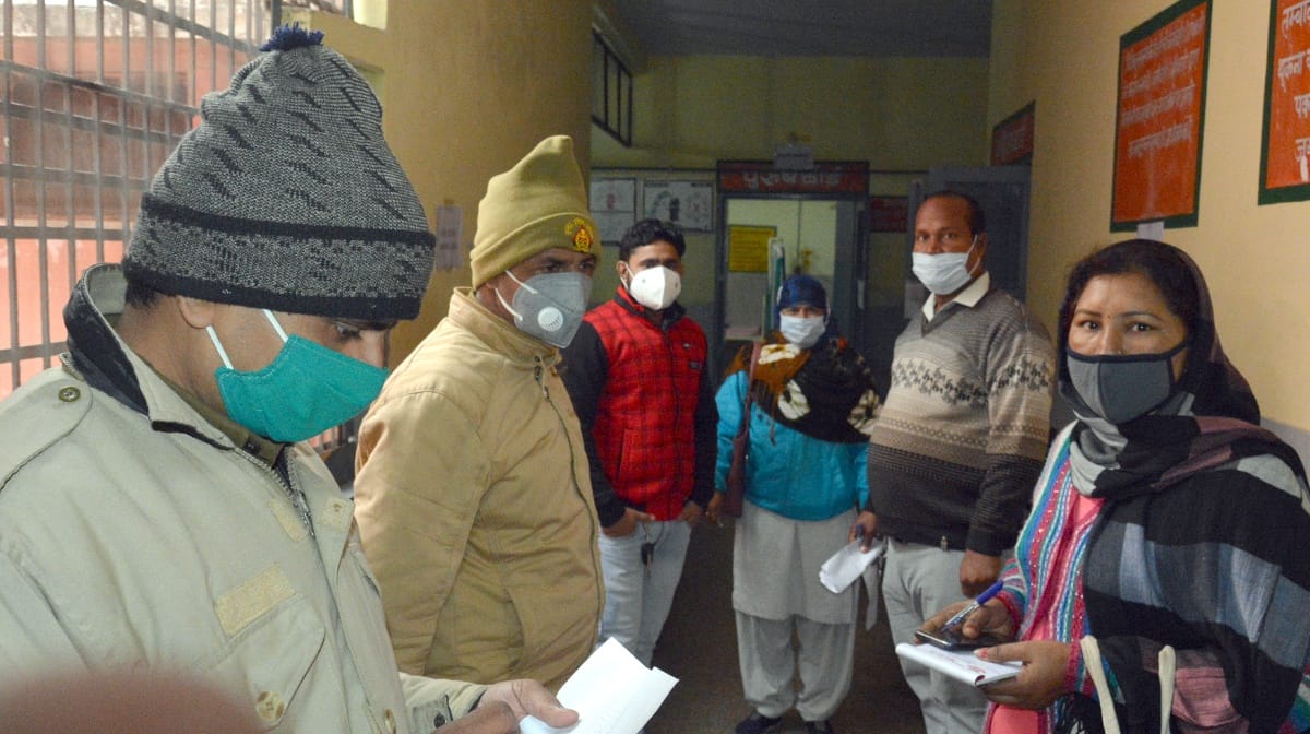 Policemen check the ID of health workers