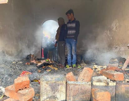 कायमगंज में दुकान में लगी आग से जले सामान को देखता दुकानदार।