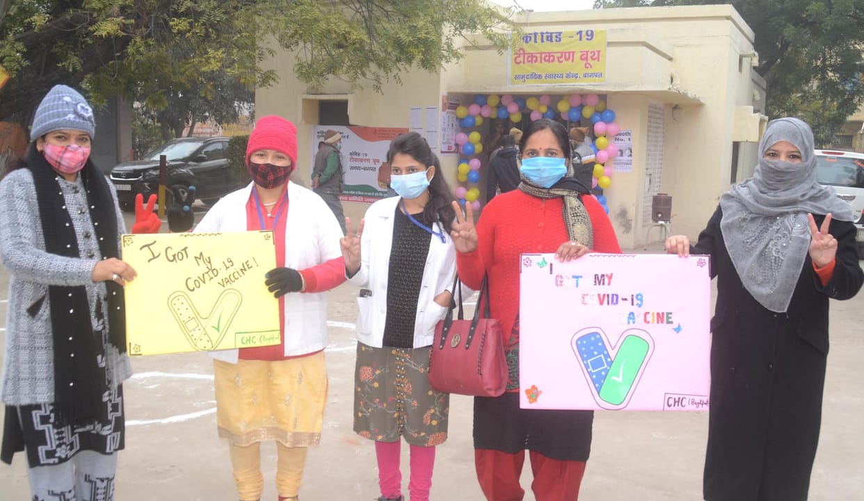 Vaccination center decorated with balloons, health workers seen excited