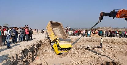 रामनगर में कोसी नदी में पलटे डंपर को क्रेन से निकालते हुए।