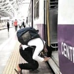 मुम्बई लोकल ट्रेन गेट पर माथा टेकता युवक