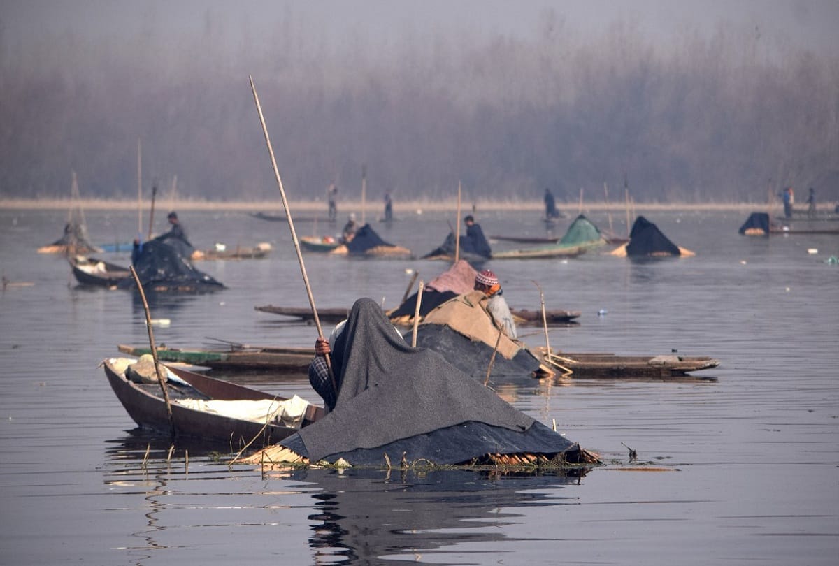 Anchar lake Srinagar kashmir Fishermen cover their heads with blankets to catch fish