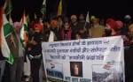 रुद्रपुर में कैंडल मार्च निकालते किसान।