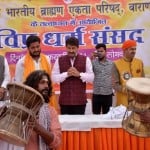धर्म संसद में मनोज तिवारी का डमरू बजाकर स्वागत करते डमरू दल के सदस्य।
