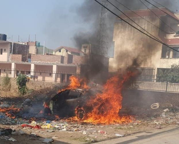 Fire on a car parked in an empty plot