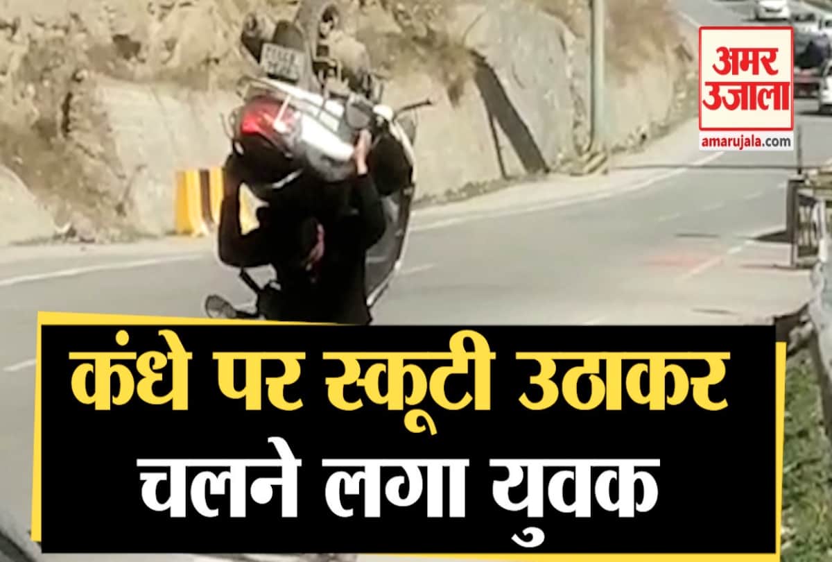 युवक ने कंधे पर उठाई स्कूटी।