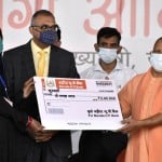 नूरजहां को चेक देते सीएम योगी।