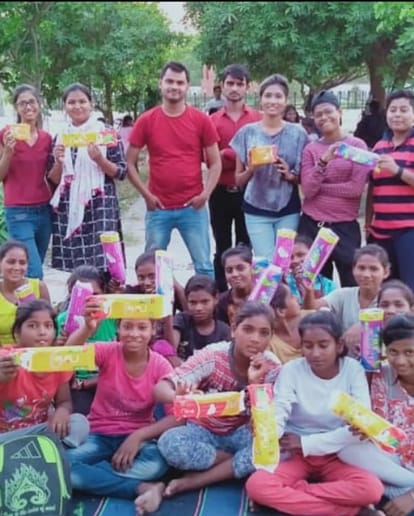 लड़कियों को पैड बांटते अभिषेक और उनकी टीम के साथी।