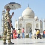 ताजमहल पर छाता लगाए सुरक्षाकर्मी