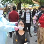 कोरोना जांच के लिए सैंपल लेती स्वास्थ्य कर्मी