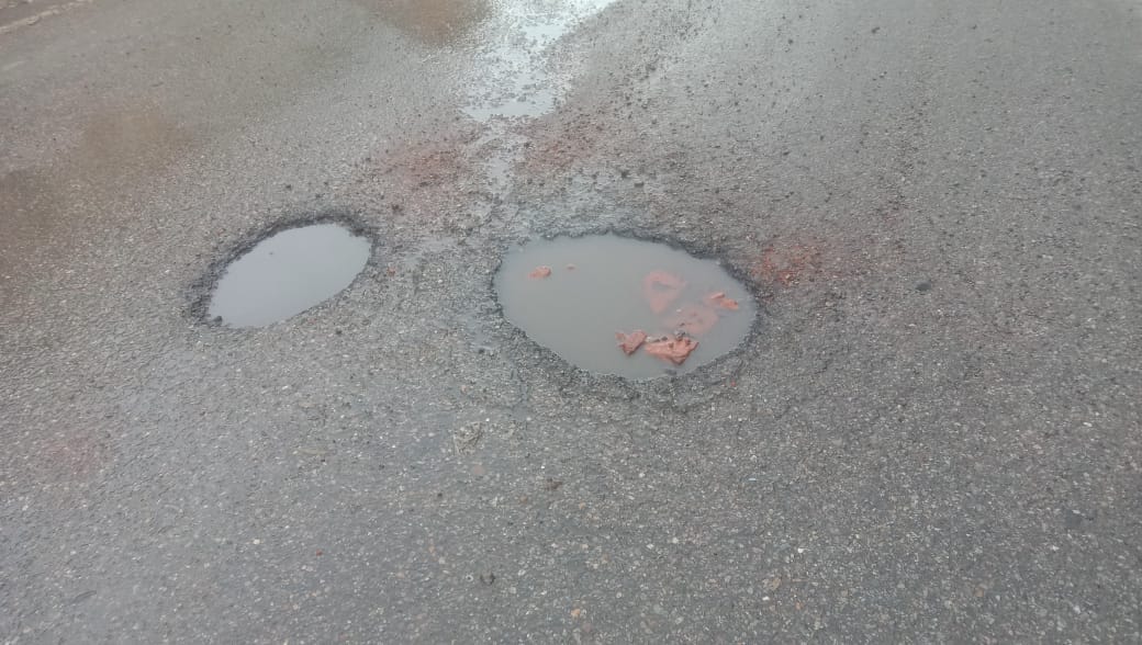 Potholes on the road in Nadaun, obstructing traffic