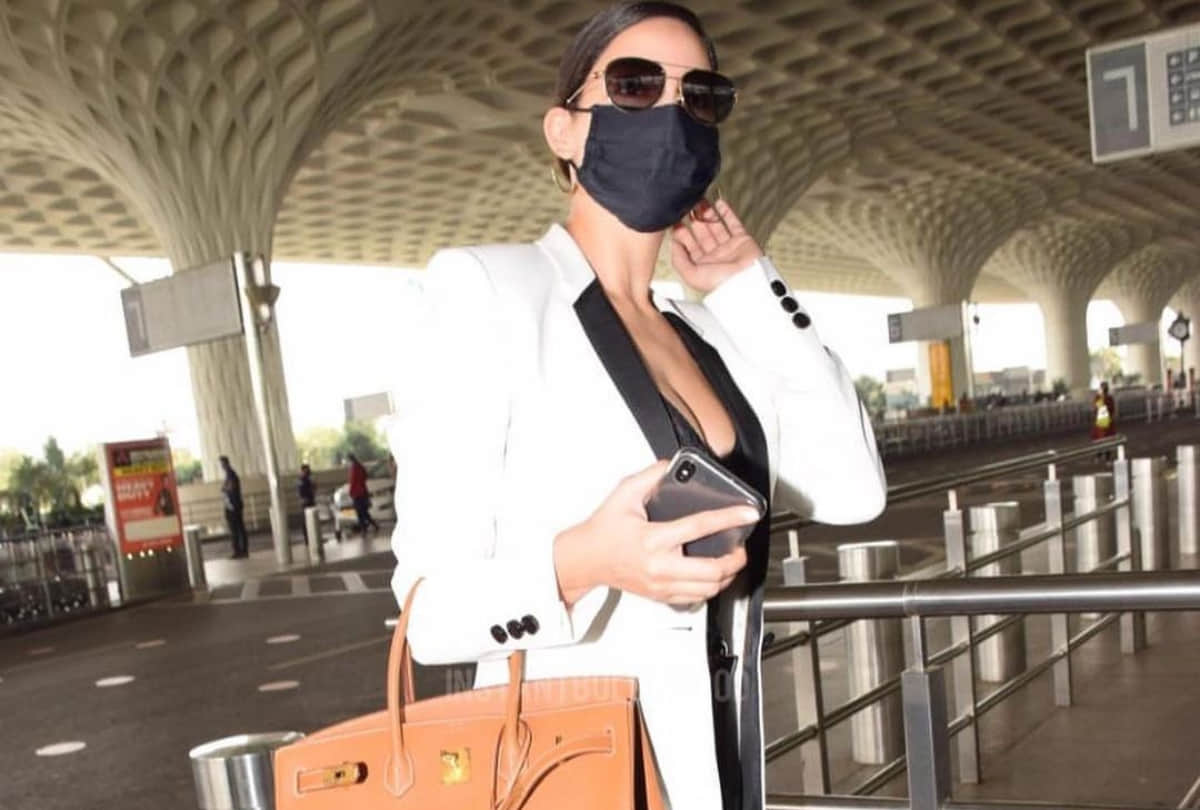 nora fatehi airport look in black corset top with white blazer and jeans