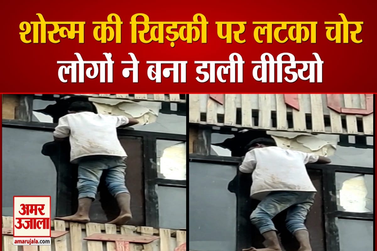 शोरूम की खिड़की पर लटका चोर
