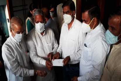 शहीद अभिनव के पिता को चैक सौंपते भाजपा नेता।