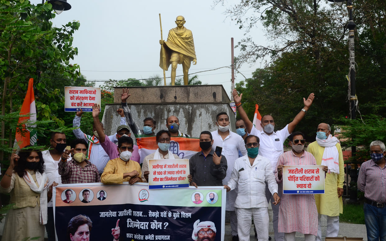 Congress workers demonstrated under Gandhi statue in Aligarh against the deaths due to spurious liquor