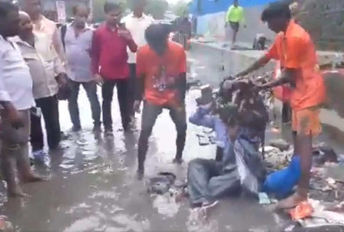 Shiv Sena MLA dilip Lande makes a contractor sit on water logged road and asks workers to dump garbage on him