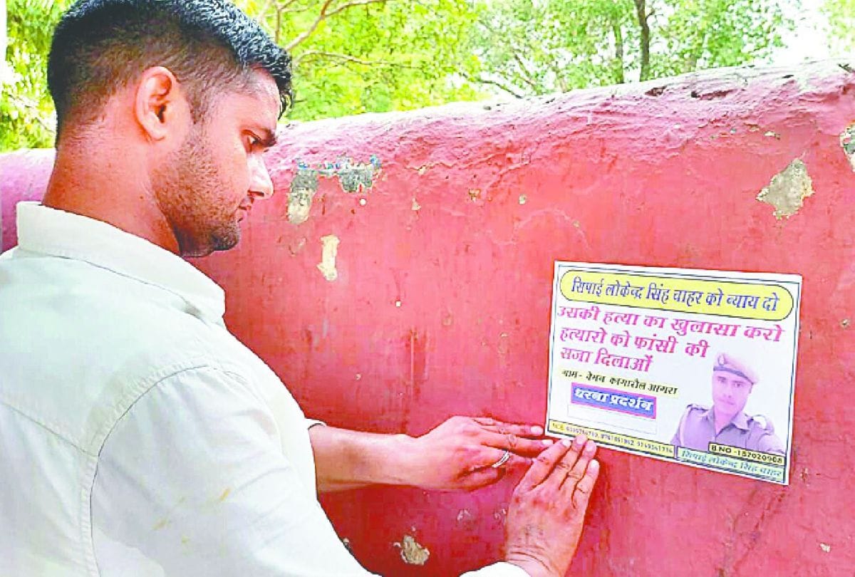 family pasting the poster for Justice in constable death case in agra