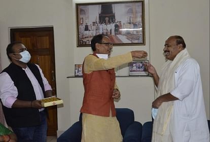 केंद्रीय मंत्री वीरेंद्र कुमार को मिठाई खिलाते सीएम शिवराज सिंह चौहान