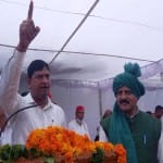 बागपत में मंच पर बोलते जिला पंचायत अध्यक्ष के पति जयकिशोर