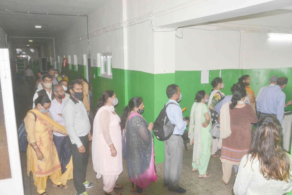 People stand in long queues for vaccination in Solan