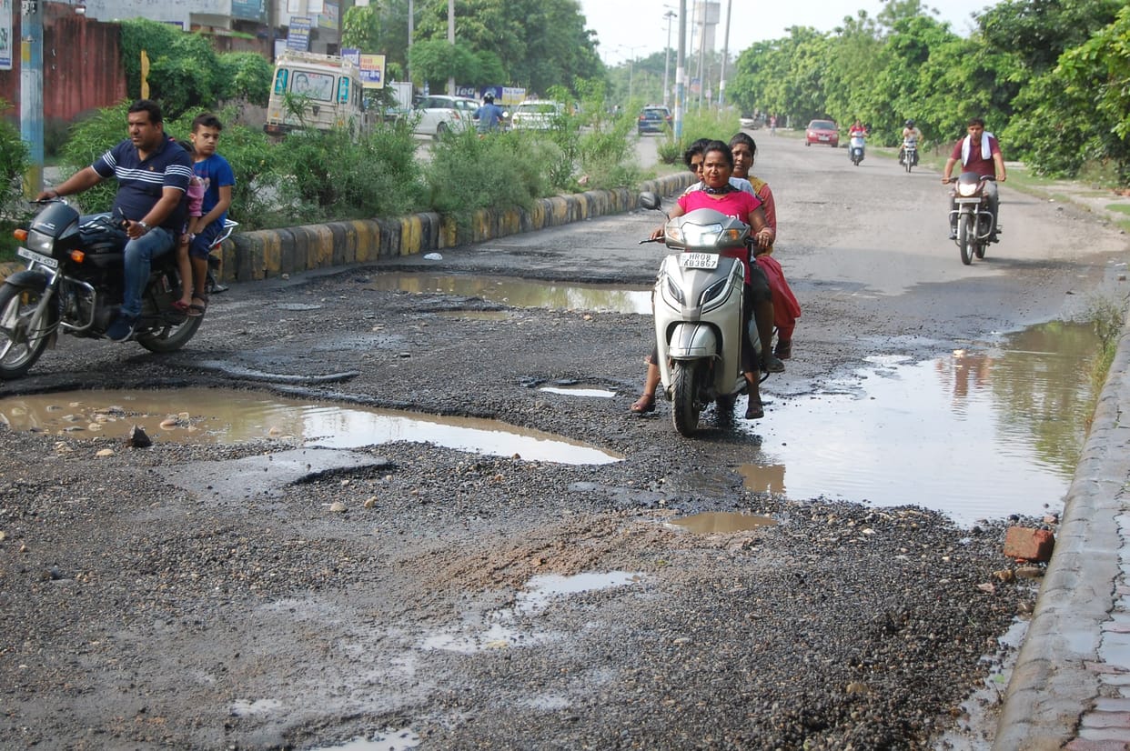 Gravel uprooted from the roads due to waterlogging, two wheeler riders slipping and falling