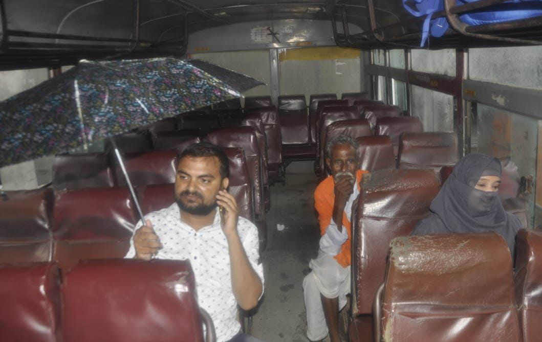 Drivers clean mirrors in rain, passengers keep umbrellas