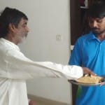 जीत के बाद सोनीपत में एक दूसरे को घेवर खिलाते सुमित के पिता प्रताप सिंह और भाई अमित।