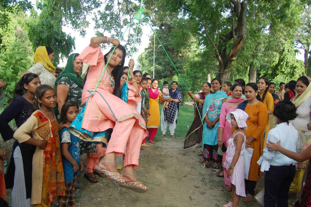 Women swing on Teej, children fly kites