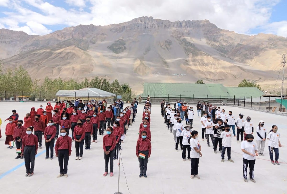 100 students sing the national anthem at the Kaza ice skating rink