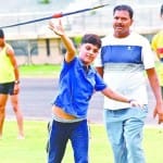 जैवलिन थ्रो की प्रेक्टिस करता बच्चा।