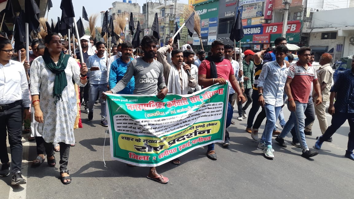 Corporation workers protested against the government by lifting black flags and inverted brooms