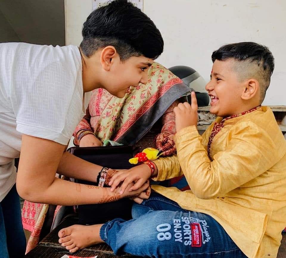 Sisters tie the cord of affection on the wrist of their brother