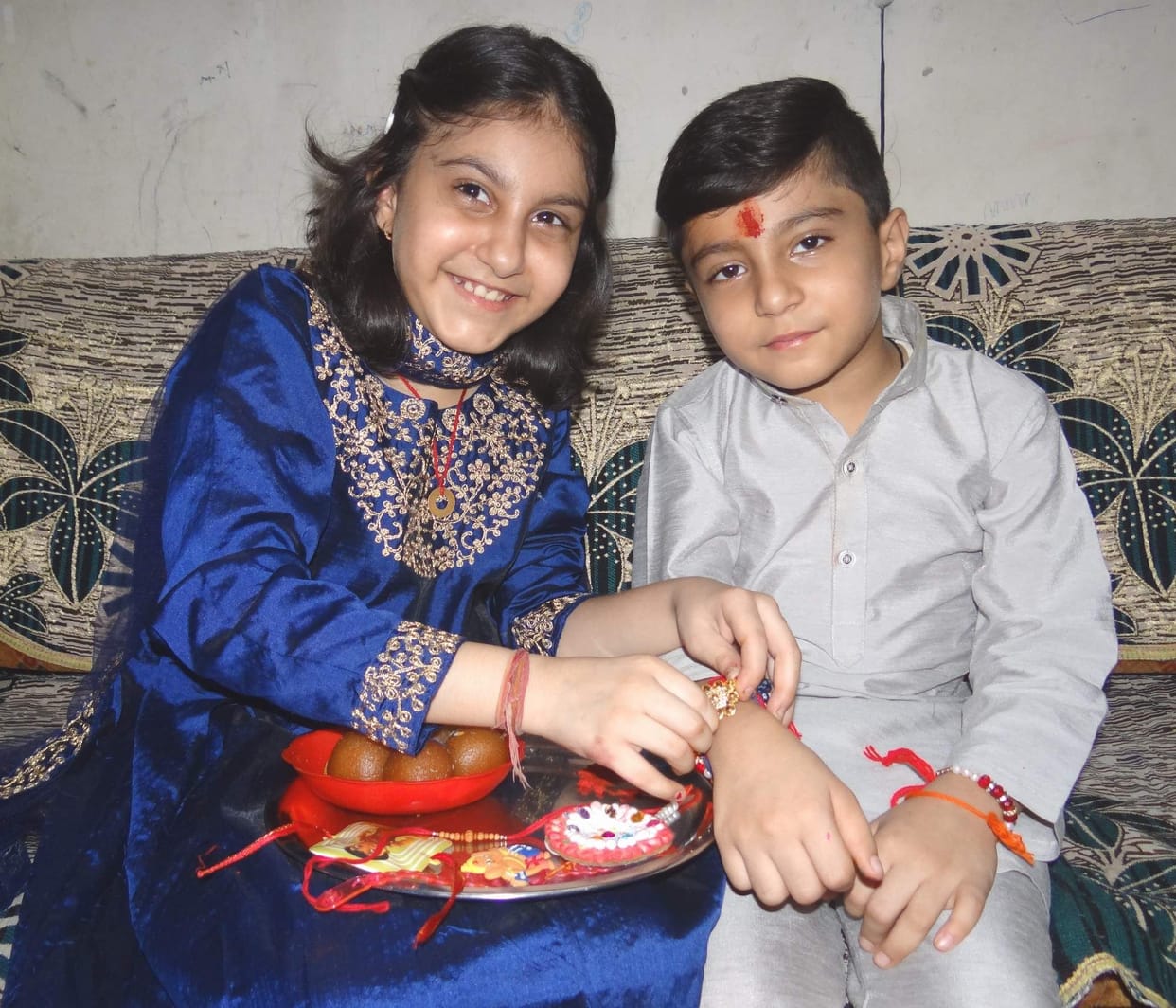 Sisters tie a thread of love on brother's wrist