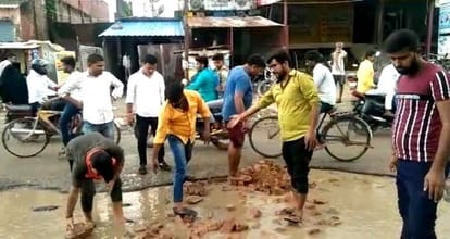 महराजगंज से बिलरियागंज जाने वाले बदहाल सड़क के गढ्डों को भरते स्थानीय लोग।