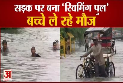 Children swim amid heavily waterlogged roads following continuous rains in the National Capital visuals from near MCD Civic Centre