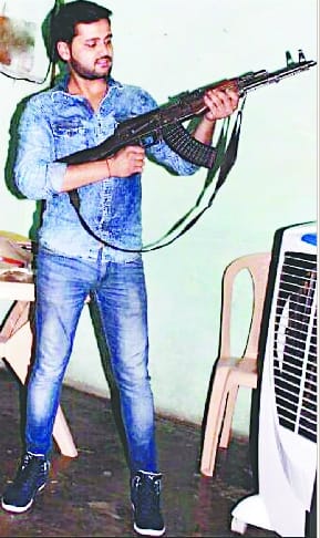 Photo of Inspector with son's AK-47 and pistol goes viral