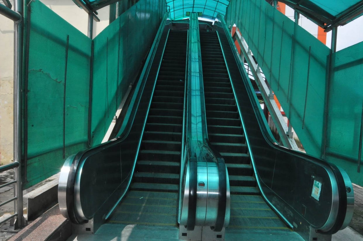 Escalator-lift facility, yet the passengers forced to cross the railway track