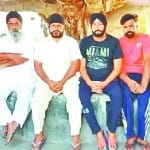 गांव में शोक जताने पहुंचे लोगों के साथ बैठे शहीद के भाई।