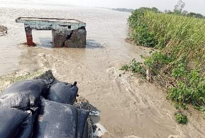 धौरहरा के समदहा में कटे तटबंध को बोरियों के जरिये बचाने की कवायद।